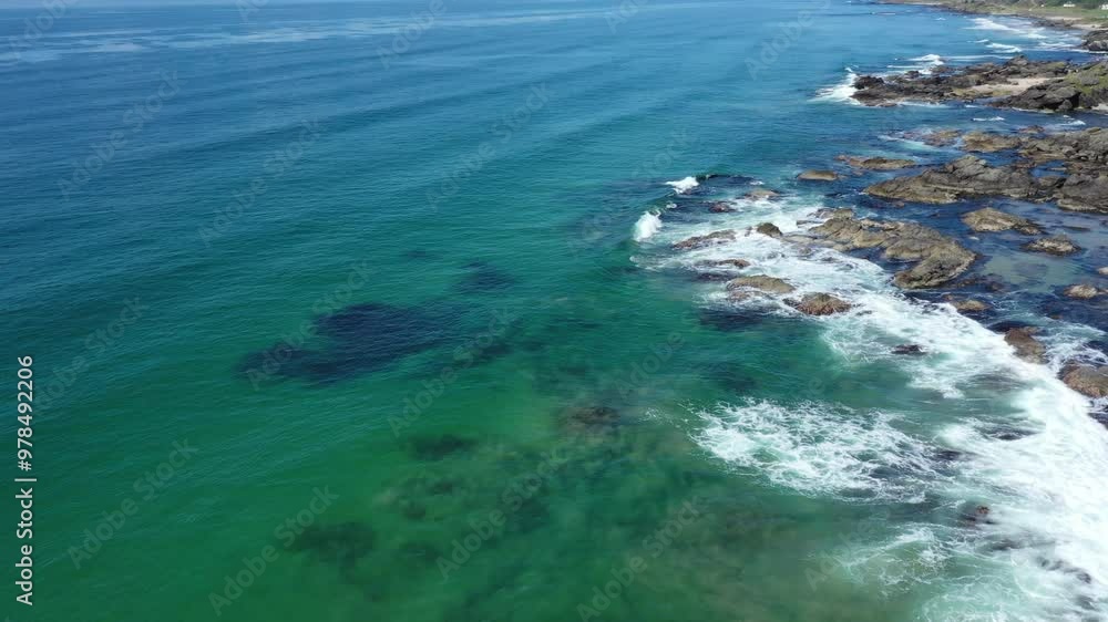 Aerial shot looking at the clear turquoise sea crashing against the rocks on the west coast of Scotland. Aerial shot looking at the clear turquoise sea crashing against the rocks on the west coast of Scotland.