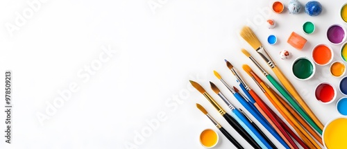 A vibrant collection of paint pots and brushes arranged on a clean white background, perfect for artistic inspiration and creativity. photo