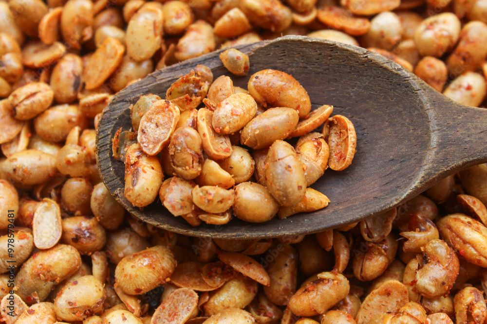 close up of peanuts with spicy seasoning on wooden spoon. background on pile of peanuts. peanut snack close up of peanuts with spicy seasoning on wooden spoon. background on pile of peanuts. peanut snack