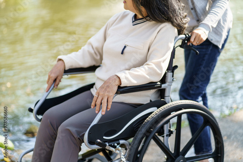 Nursing home. Young caregiver helping senior woman in wheelchair.