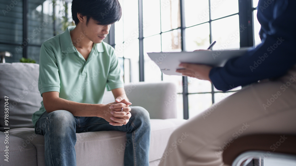 Obraz premium sad male sitting on&nbsp;sofa Patient discussing mental health issues with psychologist.&nbsp;depressed asian man mental health treatment