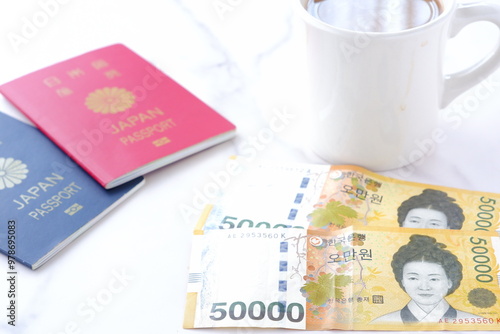 韓国の通貨、ウォンKRWの紙幣（50000ウォン札）とパスポート（一般旅券10年用赤色と一般旅券5年用紺色）を用意して韓国旅行を計画する
