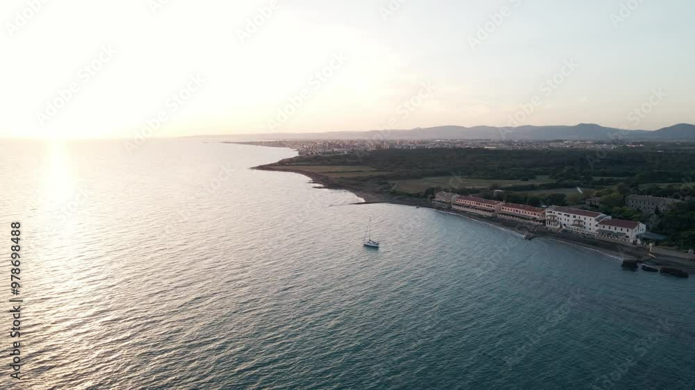 Drone shot of a sailboat on the Italian coastline during a summer sunset. Drone shot of a sailboat on the Italian coastline during a summer sunset.