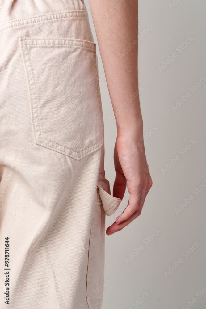 Close Up of a Person's Hand Reaching for a Pocket on Light-Colored Cargo Pants Close Up of a Person's Hand Reaching for a Pocket on Light-Colored Cargo Pants