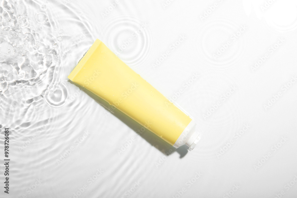 Cosmetic product. Tube with cream in water on light background, top view Cosmetic product. Tube with cream in water on light background, top view
