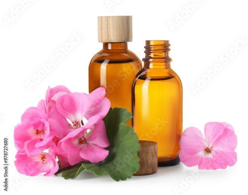 Geranium essential oil in bottles and beautiful flowers isolated on white