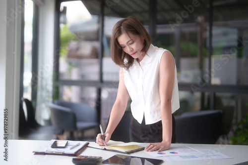 Free Download Asian businesswomen standing in outside office and working to thoughtful ideas about strategy of new business while analyze investment and market stock of new startup to taking notes in notebook - GFXLoad