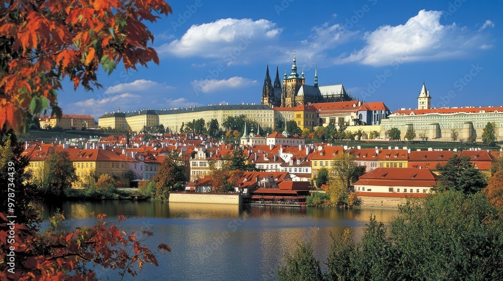 Fototapeta premium The stunning Prague Castle overlooking the Vltava River, surrounded by red rooftops.