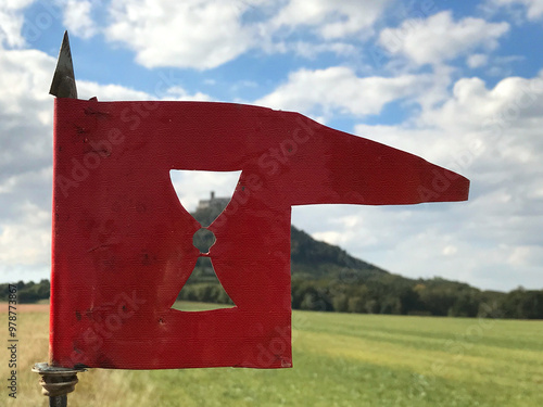 Hussite flag - a weather vane with a chalice, a medieval castle in the background photo