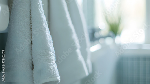 close-up of soft towels hanging in a bathroom, with the air filled with a light floral fragrance