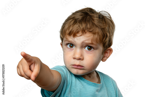 A little boy with tears in his eyes, pointing at something with a disappointed look on a white background.