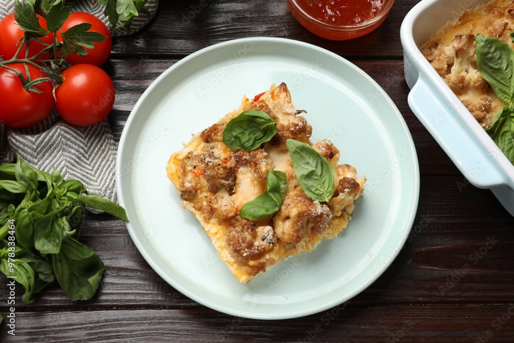 Tasty baked cauliflower, basil, parsley and tomatoes on wooden table, top view Tasty baked cauliflower, basil, parsley and tomatoes on wooden table, top view