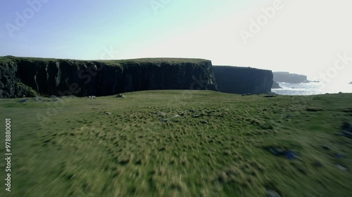 Aerial view of dramatic cliffs and the butt of Lewis lighthouse overlooking the vast sea, Ness, Scotland.