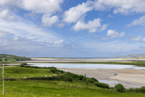 Expansive landscape of Gweebarra Bay, Ireland, during low tide, with intricate sand patterns and wide open ocean views under a blue sky photo