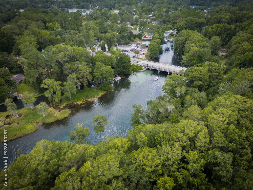 Aerial view of lush forest and tranquil river with a scenic bridge, outskirts of Rainbow River, Dunnellon, Florida, United States. Aerial view of lush forest and tranquil river with a scenic bridge, outskirts of Rainbow River, Dunnellon, Florida, United States.