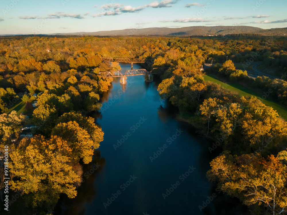 Aerial view of tranquil river and picturesque bridge surrounded by autumn foliage and serene forest, Front Royal, United States. Aerial view of tranquil river and picturesque bridge surrounded by autumn foliage and serene forest, Front Royal, United States.