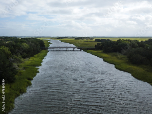 Aerial view of a serene river with a picturesque bridge surrounded by lush greenery and tranquil waters, Brunswick, United States. photo