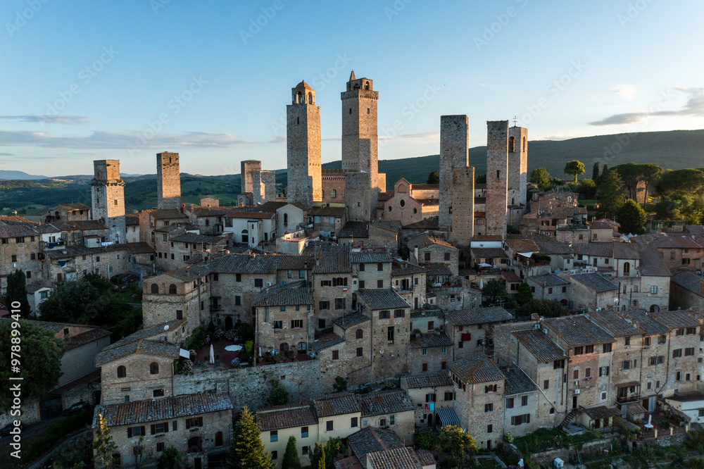 Aerial view of medieval towers and stone buildings under a clear sky, San Gimignano, Italy. Aerial view of medieval towers and stone buildings under a clear sky, San Gimignano, Italy.