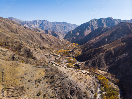 Aerial view of majestic mountains surrounding a tranquil valley with a remote village, Salang, Afghanistan. photo