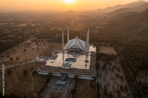 Aerial view of faisal masjid mosque at sunset with majestic mountains and serene cityscape, islamabad, pakistan. photo