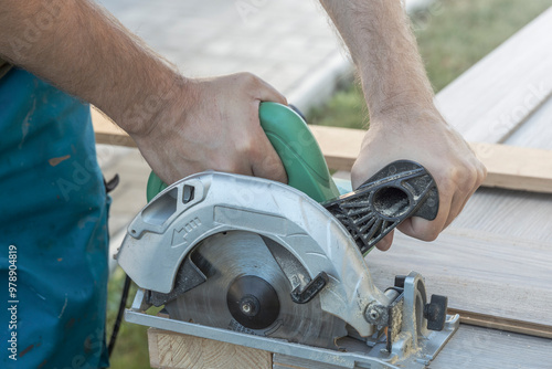 A man is using a power tool to cut wood