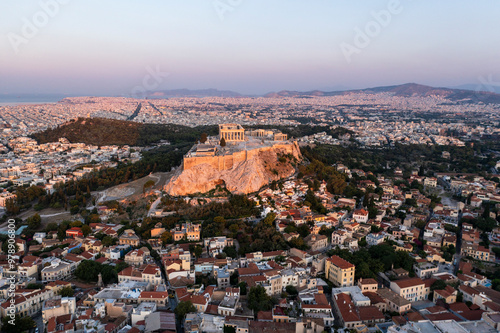 Aerial view of the historic acropolis with beautiful ancient ruins and cityscape at sunset, Athens, Greece.