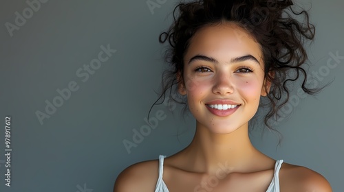 A Captivating Portrait of a Young Woman Radiating Joy and Beauty with a Bright Smile Against a Soft Neutral Background.