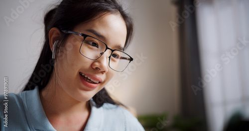 Selective focus, Female freelancer sitting at desk wear wireless headphones having video call to explain work to coworkers via digital tablet in home office. Working from home