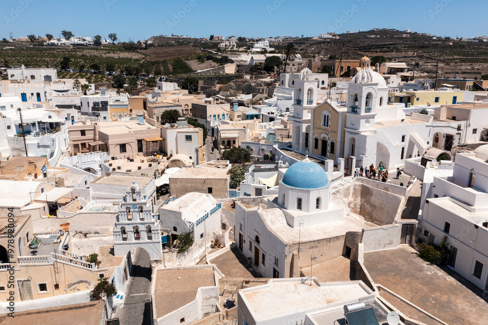 Aerial view of picturesque whitewashed houses and a blue dome church in a vibrant old town, Megalochori, Greece. Aerial view of picturesque whitewashed houses and a blue dome church in a vibrant old town, Megalochori, Greece.