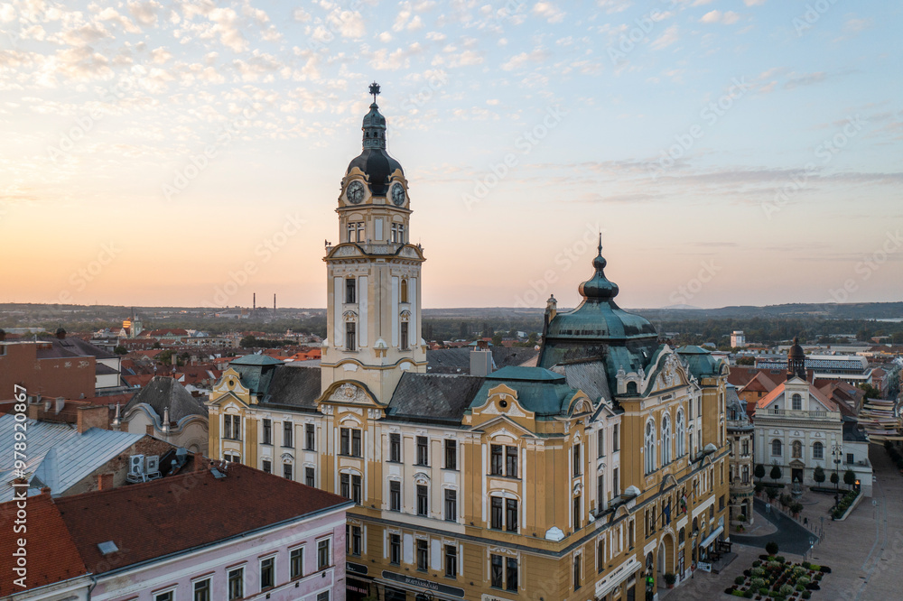 Aerial view of charming old town with historic architecture and a clock tower at sunrise, Pecs, Hungary. Aerial view of charming old town with historic architecture and a clock tower at sunrise, Pecs, Hungary.