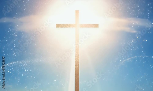 A radiant halo of light surrounds the cross against a clear blue sky, with tiny, sparkling particles drifting softly, creating a sense of divine holiness.