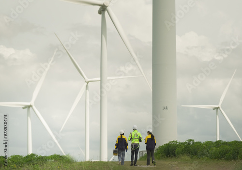  engineering technicians supervise wind power wind turbines during a sunny and windy day. Renewable and sustainable energy, technology applied to the circular green economy, expert and professional