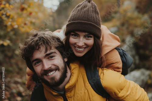 Couple enjoying a playful moment on a hiking trail surrounded by fall foliage in a forest during the autumn season