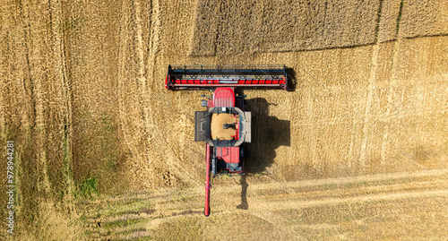 Aerial view of green farmland with combine harvester during grain harvest, Haddington, United Kingdom. photo