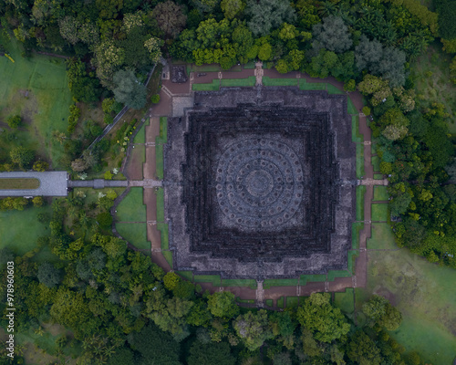 Aerial view of the ancient Borobudur temple surrounded by lush greenery at sunrise, Yogyakarta, Indonesia. photo