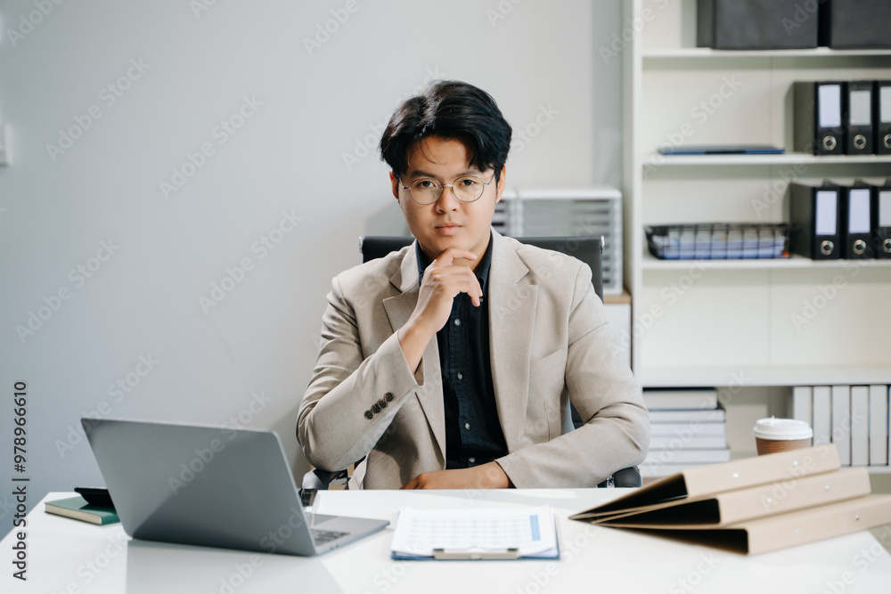 Young business man working at office with laptop, tablet and taking notes on the paper.. Young business man working at office with laptop, tablet and taking notes on the paper..