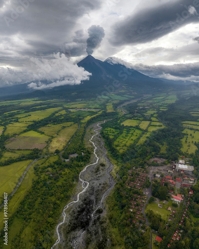 Aerial view of the majestic Fuego volcano with lava and rocks alongside the Achiguate river under a dramatic sky, Escuintla, Guatemala. photo