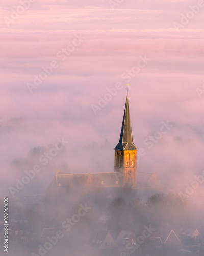 Aerial view of a serene city shrouded in fog with a church at sunrise, Workum, Netherlands. photo