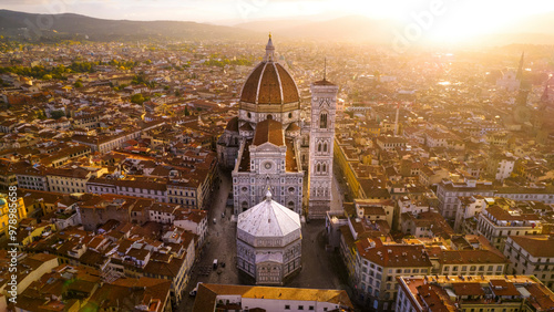 Aerial view of the iconic Santa Maria del Fiore cathedral and medieval rooftops at sunrise, Florence, Italy.