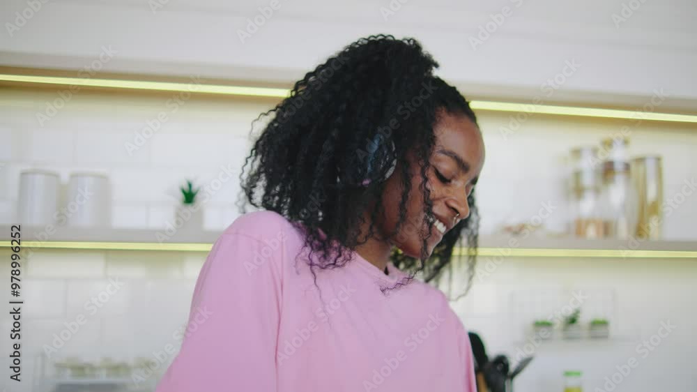 A cheerful young woman with curly hair is engrossed in a smartphone conversation, highlighting the importance of modern communication technology in our daily interactions A cheerful young woman with curly hair is engrossed in a smartphone conversation, highlighting the importance of modern communication technology in our daily interactions