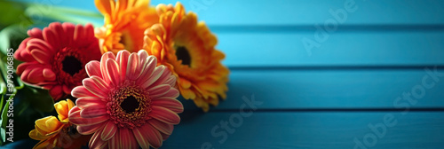 Red un orange flowers and green leaves on a blue wooden background. Thank You Day. Bouquet of gerberas. Horizontal banner. Copy space. Happy Valentine's Day. Mother's Day. Woman Day. Teacher's Day