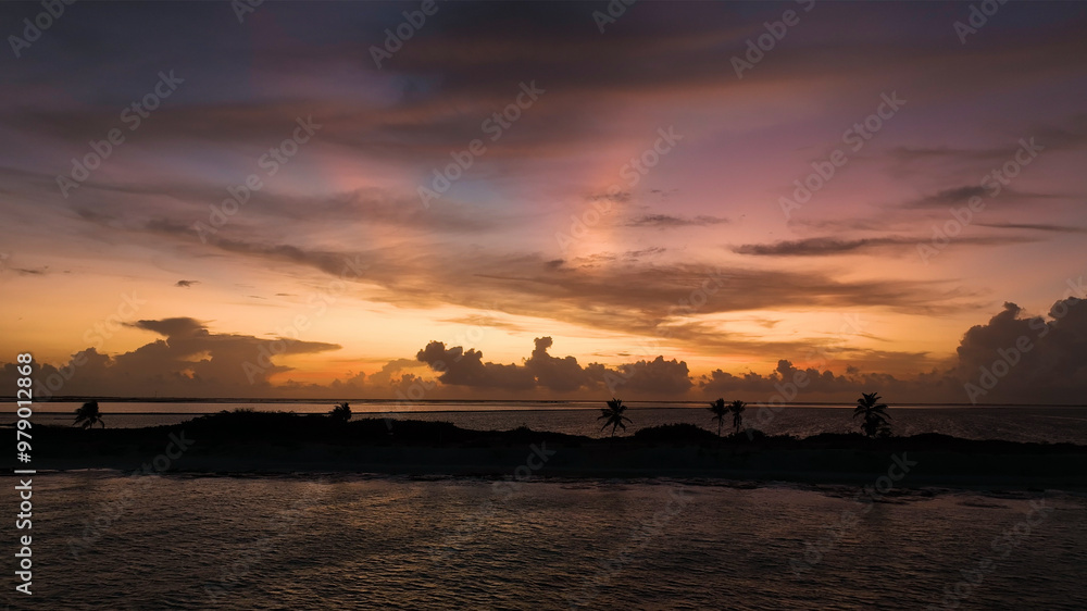 Aerial view of a serene tropical island at sunrise with palm trees and tranquil sea, Bonaire, Caribbean Netherlands. Aerial view of a serene tropical island at sunrise with palm trees and tranquil sea, Bonaire, Caribbean Netherlands.