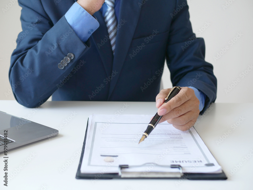 Businessman employer looking for resume to hire candidate, holding resume to hire candidate, analyzing data before job interview, recruiting concept Businessman employer looking for resume to hire candidate, holding resume to hire candidate, analyzing data before job interview, recruiting concept