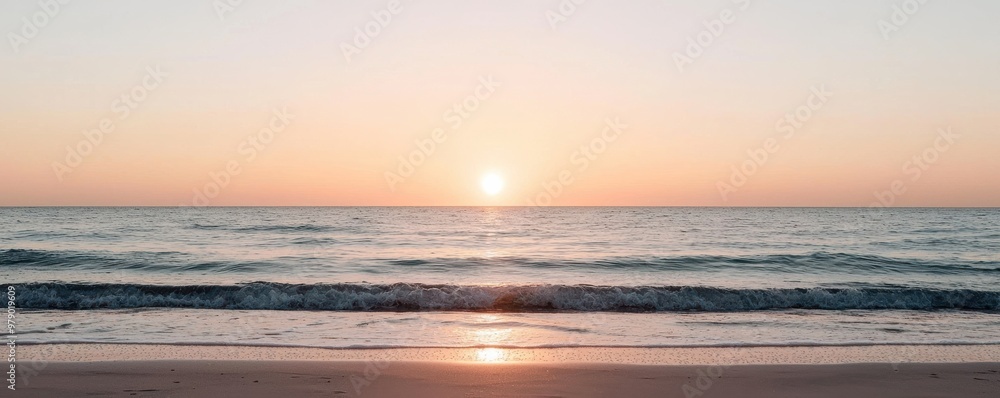Obraz premium A breathtaking view of a sunset over a calm ocean, capturing serene hues of orange and pink reflecting on the water's surface.