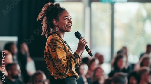 Happy businesswoman standing with a microphone in front of an audience