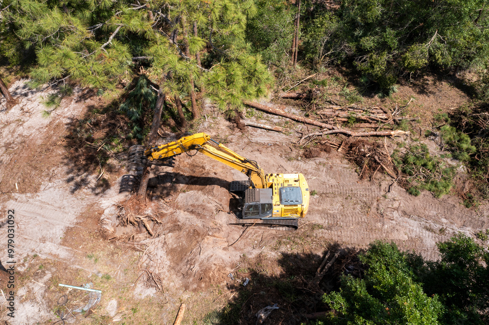Aerial view of land clearing for house construction with heavy machinery in a wooded area, Vero Lake Estates, United States. Aerial view of land clearing for house construction with heavy machinery in a wooded area, Vero Lake Estates, United States.