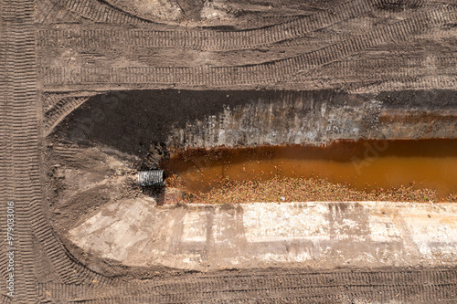 Aerial view of drainage canal with brown water and surrounding soil patterns, Fellsmere, Florida.