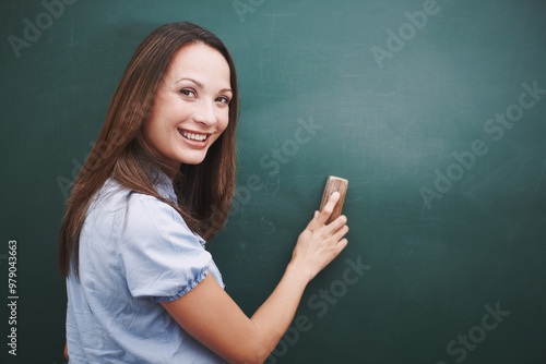 Portrait, teacher and happy woman erase chalkboard for learning, education or mockup space. Class, teaching and person wipe board to prepare for lesson, course or face at elementary school in Germany photo