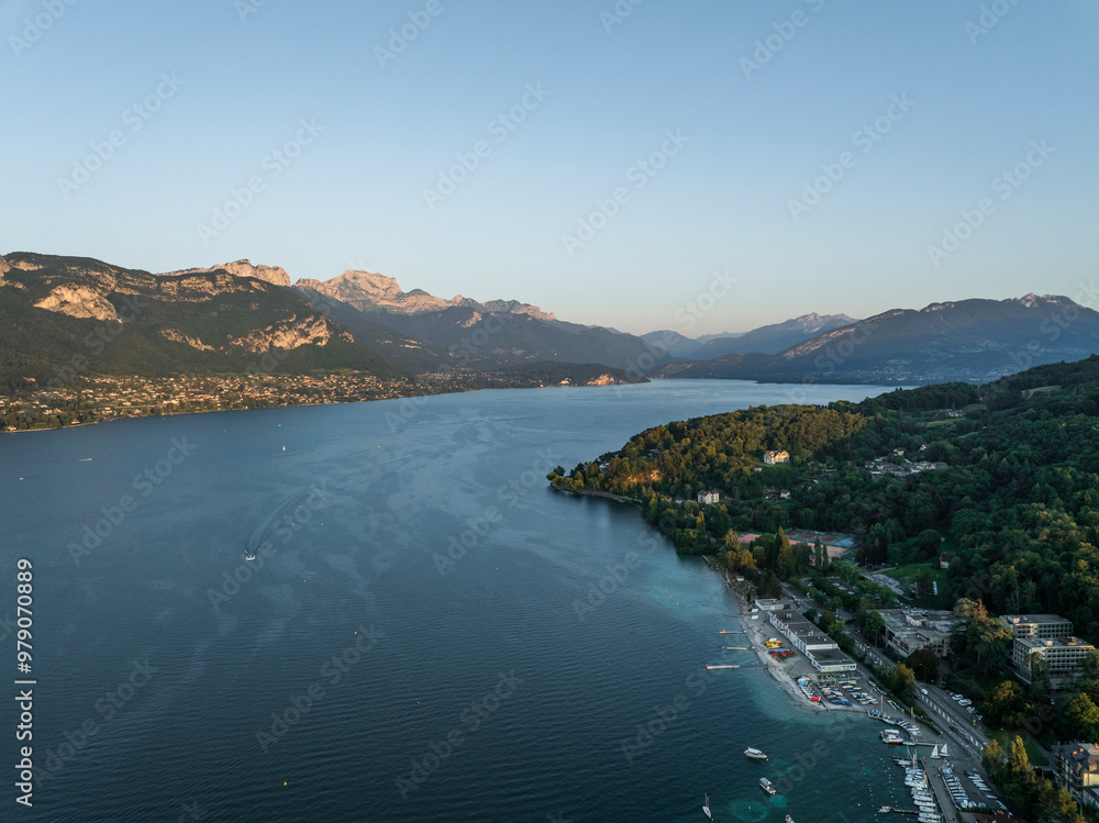 Aerial view of serene Annecy Lake surrounded by picturesque mountains and lush forests, Marquisats, France. Aerial view of serene Annecy Lake surrounded by picturesque mountains and lush forests, Marquisats, France.