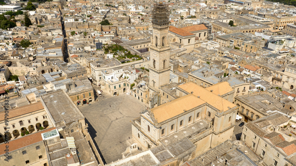 Aerial view of the cathedral of Lecce, in Apulia, Italy. The metropolitan cathedral of Santa Maria Assunta with its tall bell tower is located in Piazza del Duomo, in the historic center of the city. Aerial view of the cathedral of Lecce, in Apulia, Italy. The metropolitan cathedral of Santa Maria Assunta with its tall bell tower is located in Piazza del Duomo, in the historic center of the city.